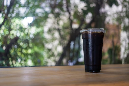 Closeup of takeaway plastic cup of iced black coffee photo
