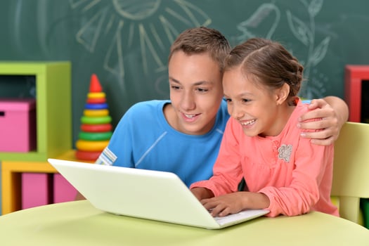 Portrait of brother and sister using laptop photo