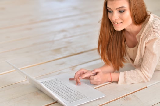 Adult beautiful woman lying on floor with laptop photo