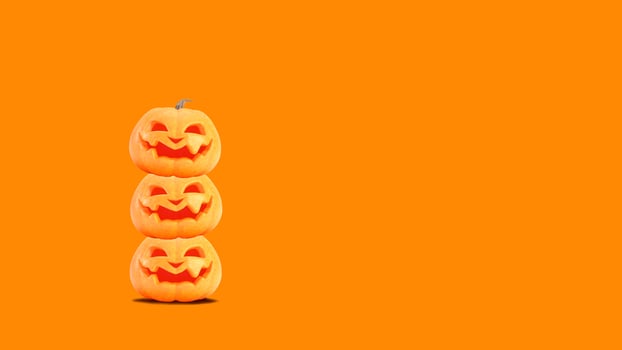 Halloween pumpkins smiles on orange background with copyspace. Jack o lanterns on Halloween backdrop photo