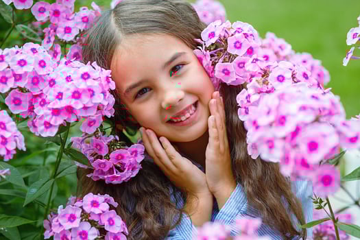Adorable little girl in pink flowers phlox photo