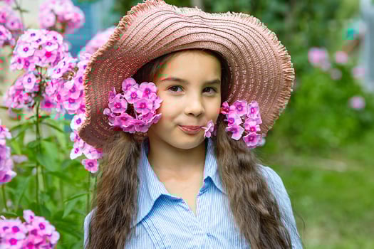 cute little girl in hat with pink flowers phlox photo