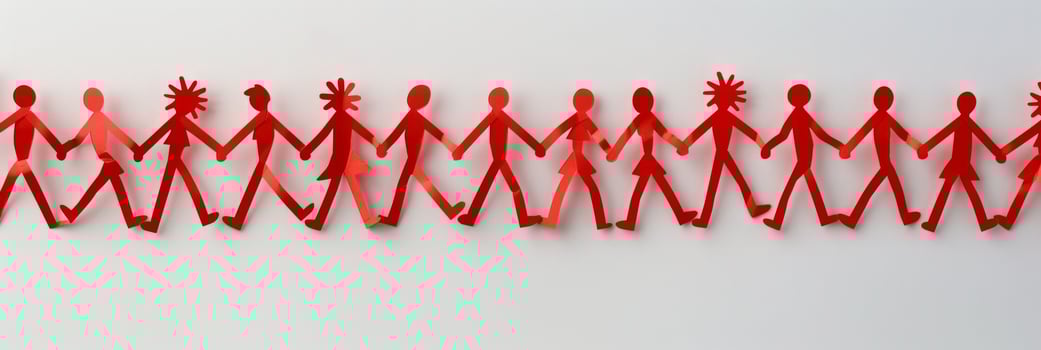 Top-down view of interconnected red paper cutout people holding hands, forming a chain photo