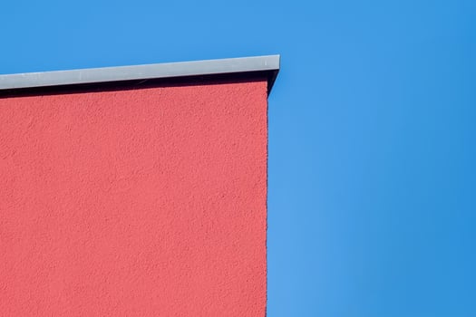 orange painted house wall in front of a blue sky photo