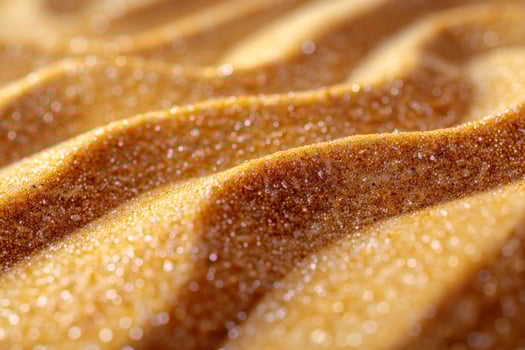 Close-up of golden sand with detailed ripples and swirls, sparkling in the sunlight photo