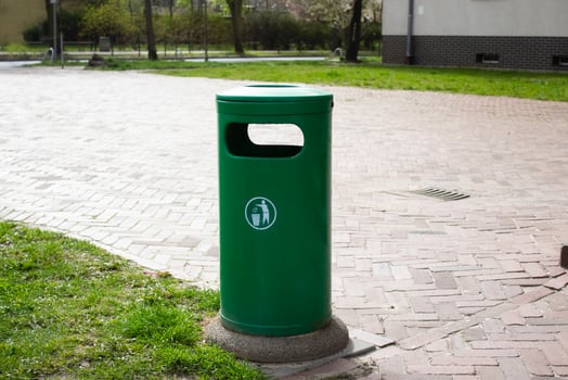 Public trash can on a city street filled with garbage photo