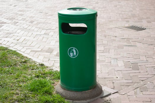 Public trash can on a city street filled with garbage photo