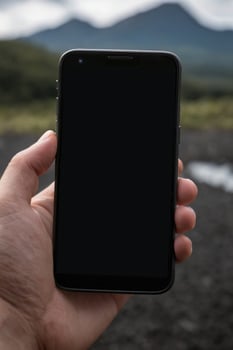 Close-up of a person's hand holding a smartphone photo