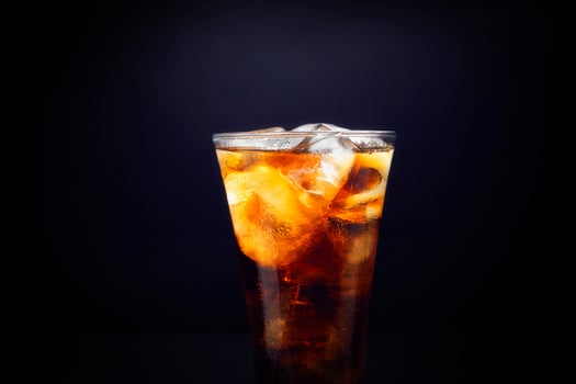 Close-up of soft drinks A glass of delicious refreshing summer water with ice cubes, isolated on black background. Closeup photo