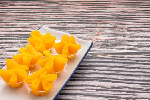 Thai dessert Khanom Thong Yip is placed on a plate placed on gray stone background. Space for text. Concept of sweet dessert photo