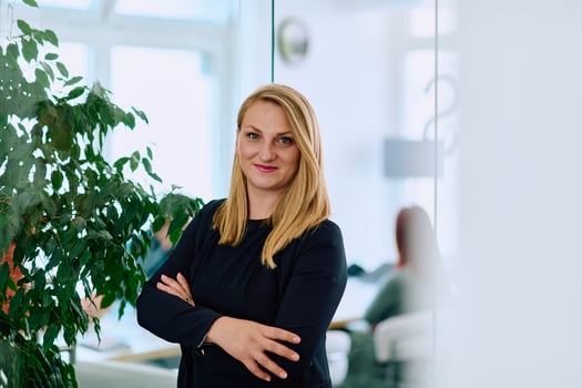Brunette Businesswoman with Crossed Arms Standing in Front of Modern Office. photo