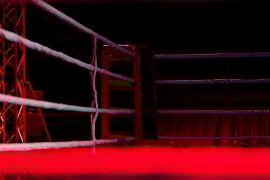 Empty boxing ring with red ropes for match in the stadium arena. Creative artwork decoration. Foggy background with light. Selective focus photo