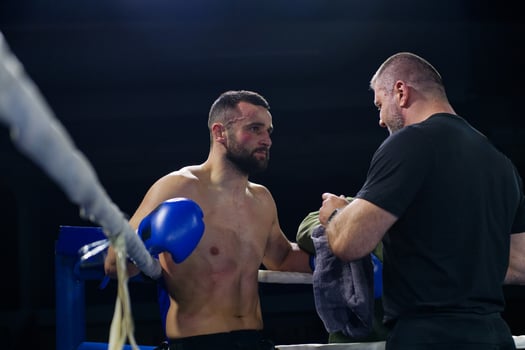 Cornered boxer receives strategic advice from trainer during intense bout. photo