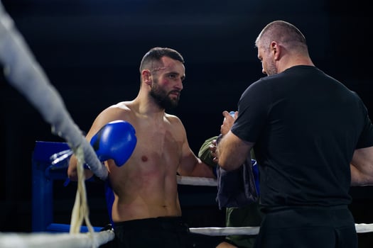 Cornered boxer receives strategic advice from trainer during intense bout. photo