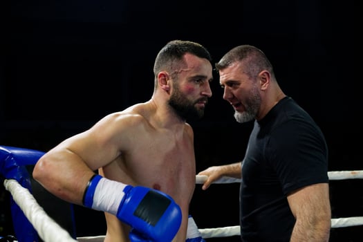 Cornered boxer receives strategic advice from trainer during intense bout. photo