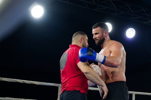 A boxer celebrates victory with his team in an emotional embrace after a grueling match. photo