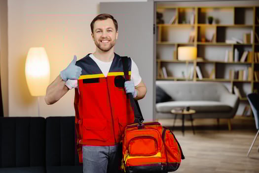First aid course. A young male paramedic with a bag on his shoulders is standing in a classroom before a lecture photo