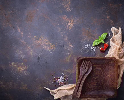 Empty wooden plate, cutlery, salt, pepper and basil photo