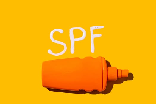 Sunscreen SPF cream on yellow background photo