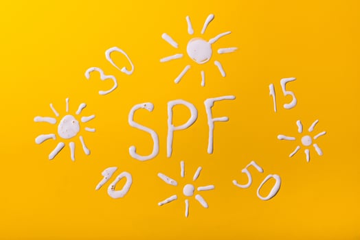 Sunscreen SPF cream on yellow background photo