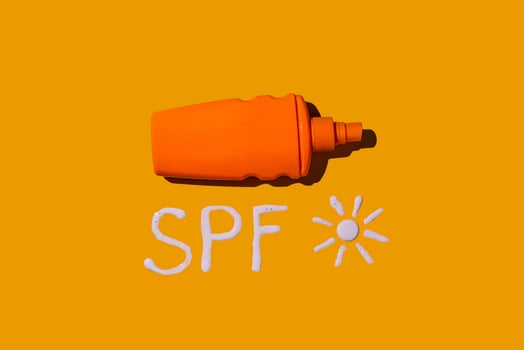 Sunscreen SPF cream on yellow background photo