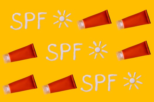 Sunscreen SPF sunblock cream on yellow background photo