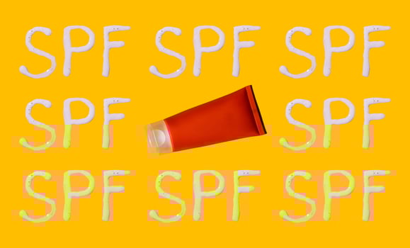 Sunscreen SPF sunblock cream on yellow background photo