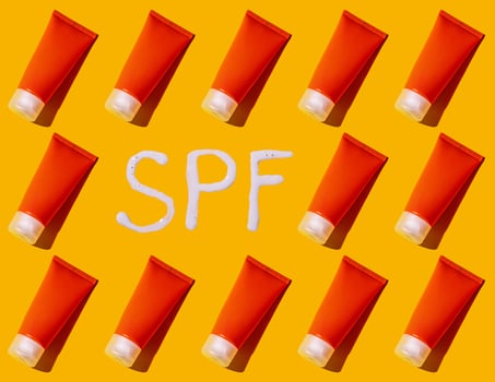 Sunscreen SPF sunblock cream on yellow background photo