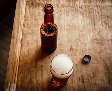 Opened beer bottle, bottle cap and glass with beer photo