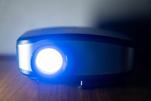 Projector emitting bright blue light on wooden surface photo