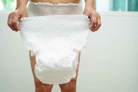 Asian senior woman patient wearing adult incontinence diaper pad in hospital. photo