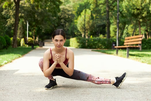 Young fitness woman runner stretching legs before run photo