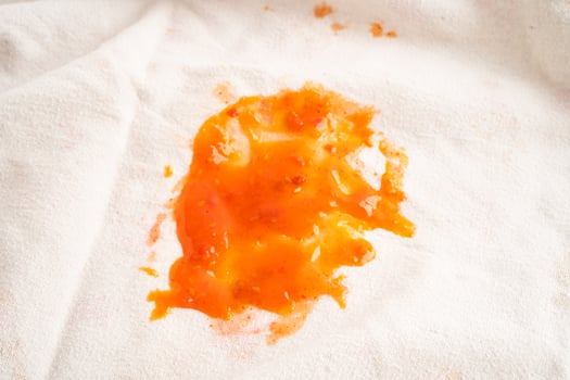 Dirty tomato sauce stain or ketchup on cloth to wash with washing powder, cleaning housework concept. photo