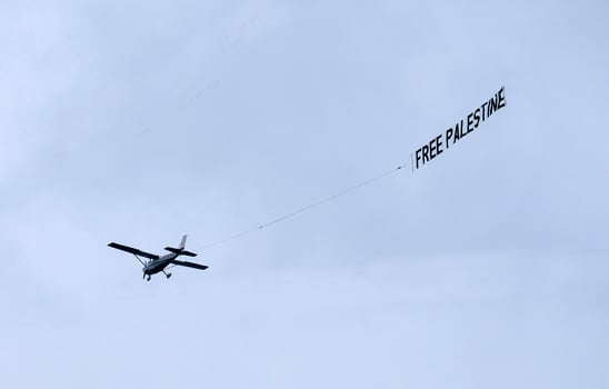 A plane with a Free Palestine banner in the sky photo