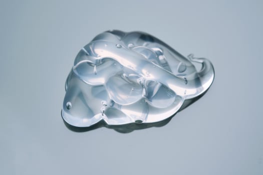 Texture of cosmetic hyaluronic gel or gel lubricant on a green background. photo