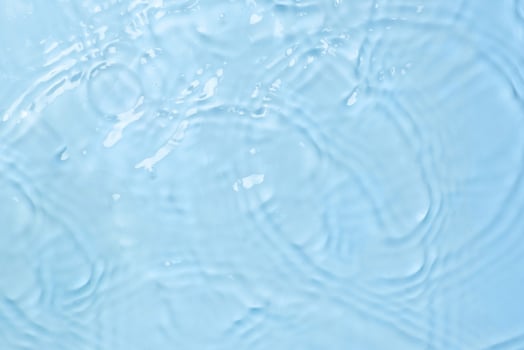 Blue water background with waves and drops top view photo