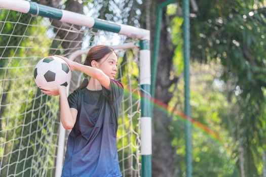 Asian kid girl with a ball at outdoor futsal sports field photo
