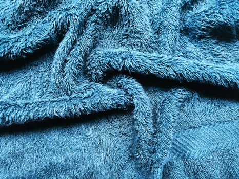 Blue background of towel texture. Beautifully folded white towels. Macro photo of beach towel. Soft textile background