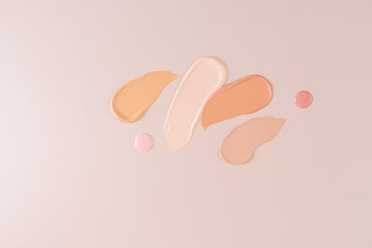 samples of liquid foundation powder in different tones and two round drops of cream on a beige background. top view. cosmetic design photo