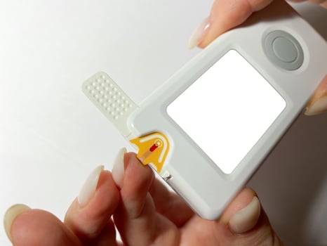 Measurement of blood sugar levels using a glucose meter with a mock-up. Piercing a finger to draw blood photo
