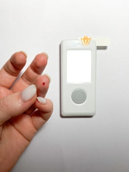 Measurement of blood sugar levels using a glucose meter with a mock-up. Piercing a finger to draw blood photo