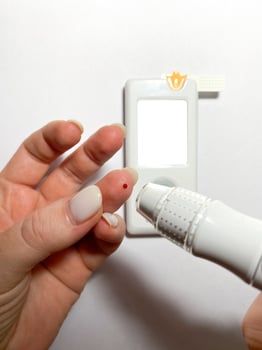 Measurement of blood sugar levels using a glucose meter with a mock-up. Piercing a finger to draw blood photo