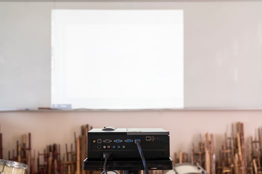 Projector in action with illuminated, teacher teaching schoolchildren using projector screen photo