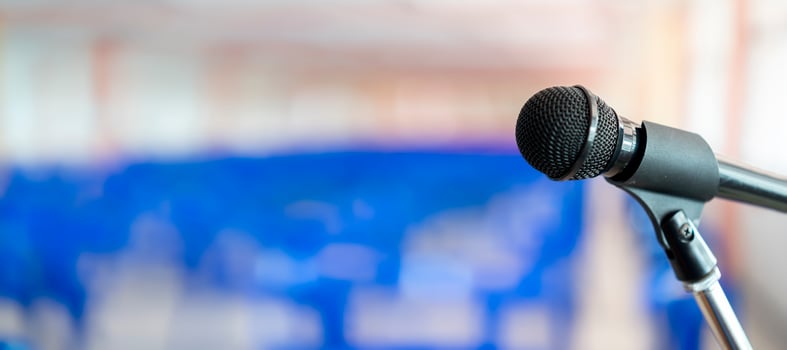 Microphone on abstract blurred of speech in seminar room or speaking conference hall light photo