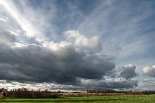 Dramatic sky with dark rain clouds over of autumnal country landscape photo