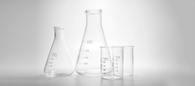 Glass chemistry lab equipment on blue background. Chemistry Lab concept, different laboratory glassware photo
