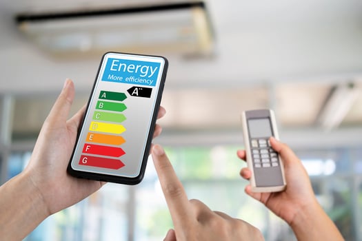 Hand holding digital smart phone and looking at house efficiency rating. Detail of house efficiency rating on digital tablet screen. Concept photo