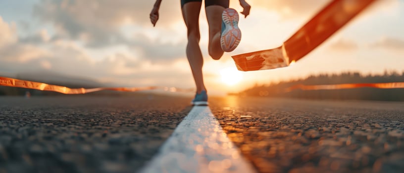 Close-up of a runner's legs crossing the finish line during a race at sunset, showcasing determination and achievement. photo