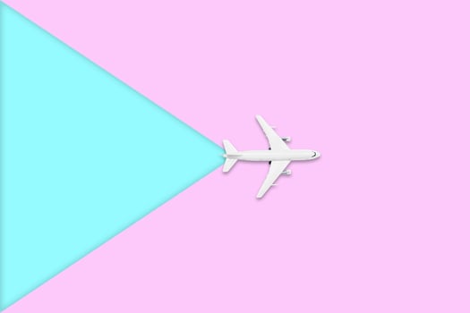 Flat lay design of travel in summer concept. Top view of an airplane on blank pink and blue pastel color screen with copy space. travel on summer trip photo