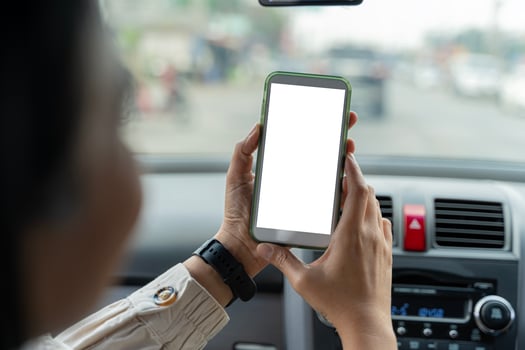 Happy couple using showing smartphone with empty screen, using mobile phone to look through navigation map during car trip photo